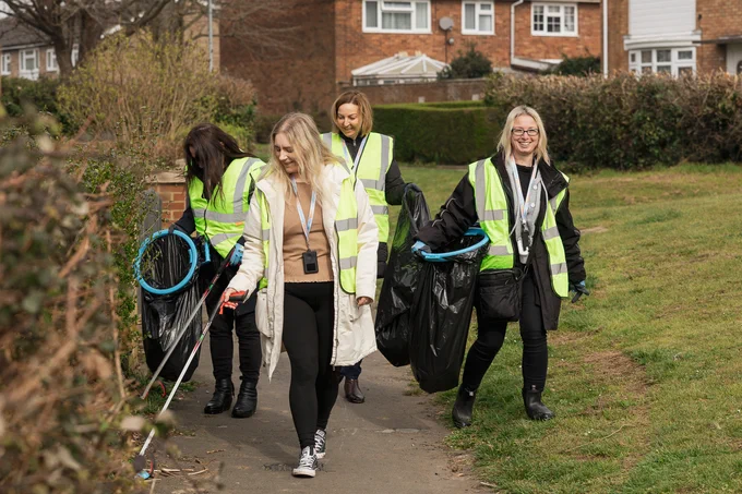 4 SettleParadigm colleagues walking along a path and litter picking