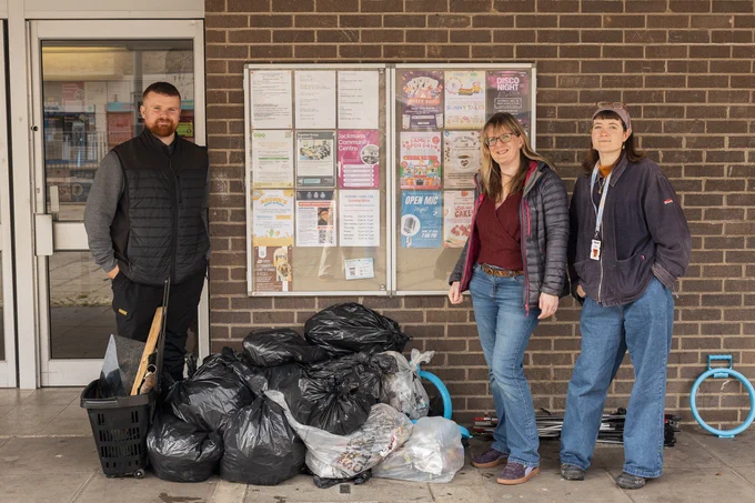 3 people standing by a collection of full rubbish bags