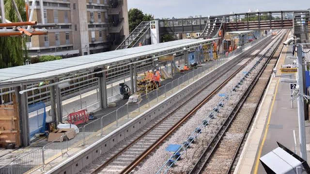 a suburban railway station undergoing engineering work with platforms being rebuilt and new track being laid 