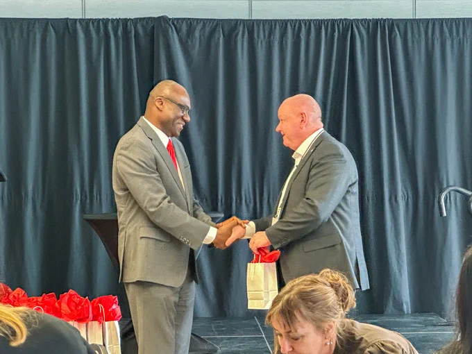 Two men in business attire shaking hands.
