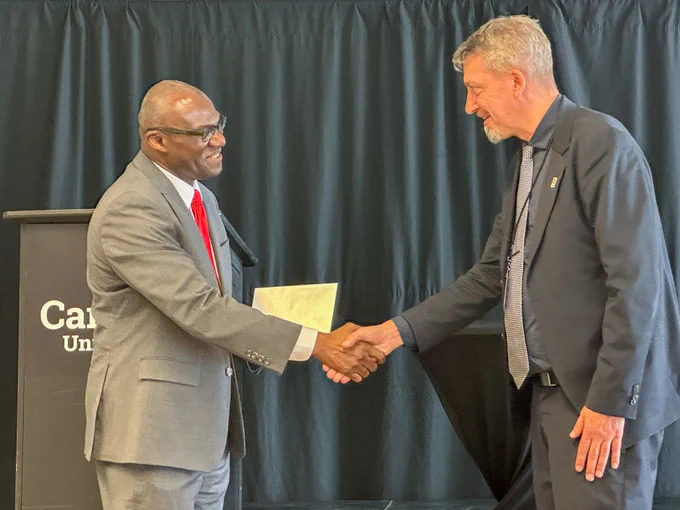Two men in business attire shaking hands.