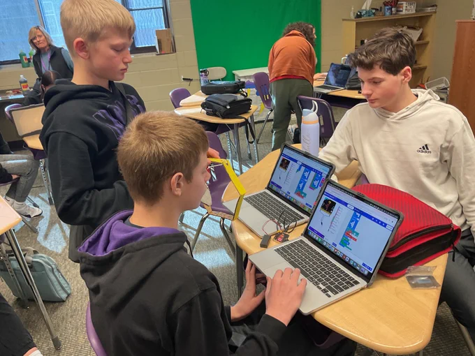 Students work on their laptops to code their pet movements. 