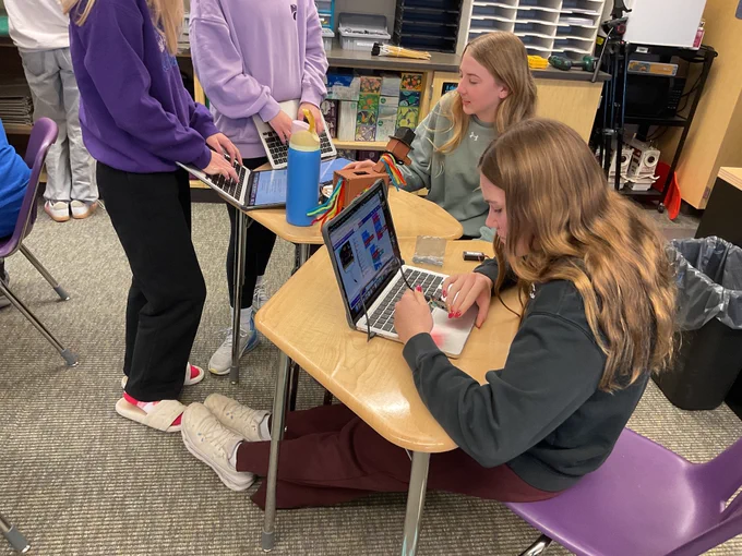 Students work on their laptops to code their pet movements. 
