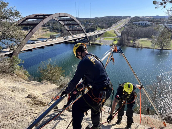 Firefighters prepare for an advanced rope rescue off the side of a cliff.