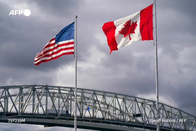 The US and Canadian flags wave in the wind