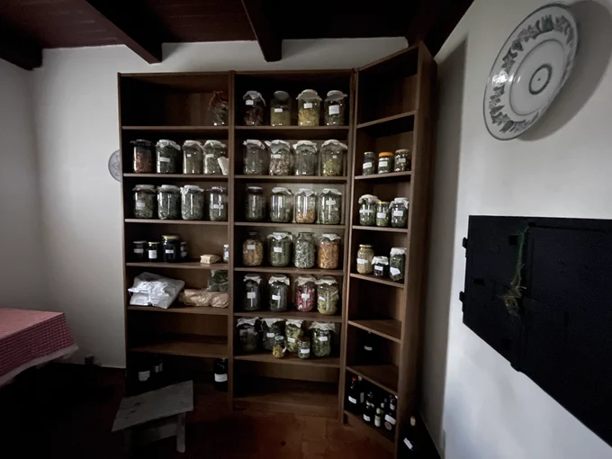 assembled shelves with many shelves stocked wiht large herb jars