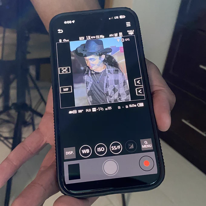 An image of Zachariah Highgate on a phone app preview. He's behind an overlayed image and wearing a black cowboy hat and checkered shirt. 