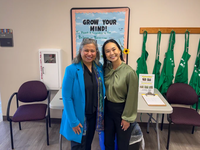 Dr. Sallam and Karen Hua posing for a photo in front of a handmade sign that reads “Grow Your Mind”.