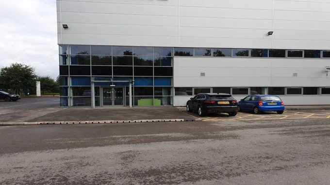 Modern office building with cars parked in front.