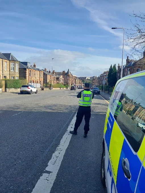 A police officer carries out a speed check in high visibility clothing