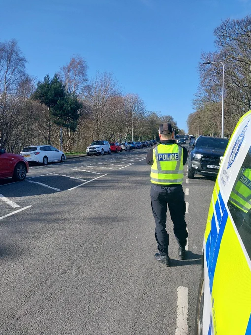 A police officer carries out a speed check in high visibility clothing