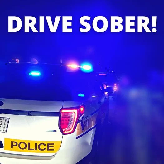 A police car with flashing blue lights at night. The text "Drive Sober!" is prominently displayed at the top of the image.