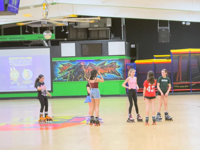A group of students chat together on the rink