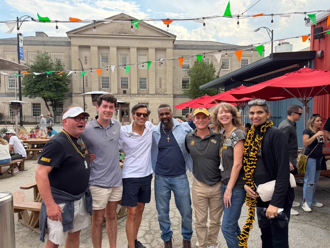 Outdoor group shot of Dr. Rao and Monica Rao with five other people, all smiling.