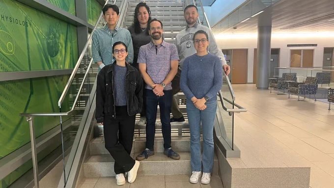 Members of the Brinsmade Lab, including biology professor Shaun Brinsmade and five grad students and postdocs, pose for a group photo on a staircase.