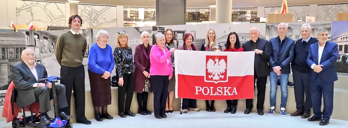 Group of people holding up a Polish flag 