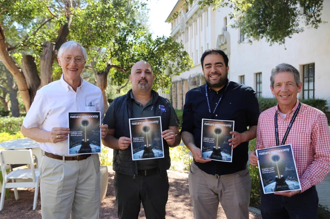 John Mather, Eliad Peretz, Ahmed Soliman, and Stuart Shaklan pose for a photo each holding a copy of the Nature Astonomy March cover