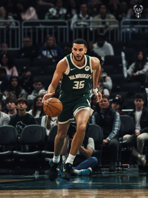 A photo of Pete Nance dribbling in a green Bucks jersey.