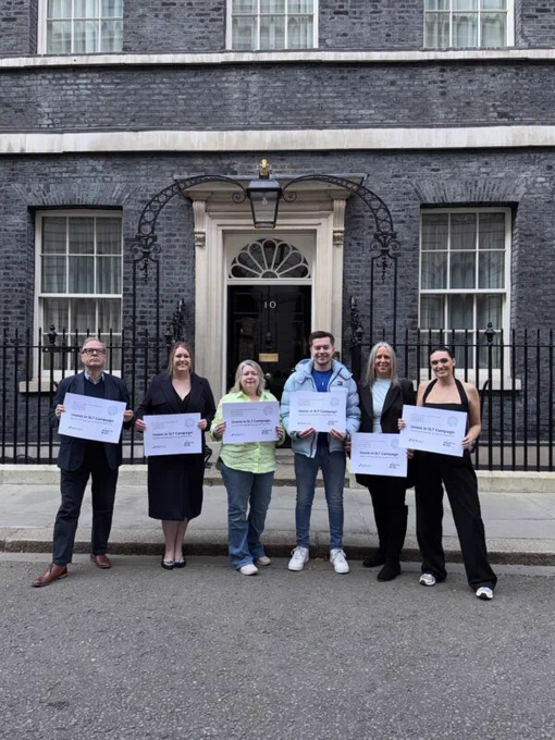 Six people stood outside 10 Downing Street in London. They are holding up cards reading 'Invest in SLT Campaign'.