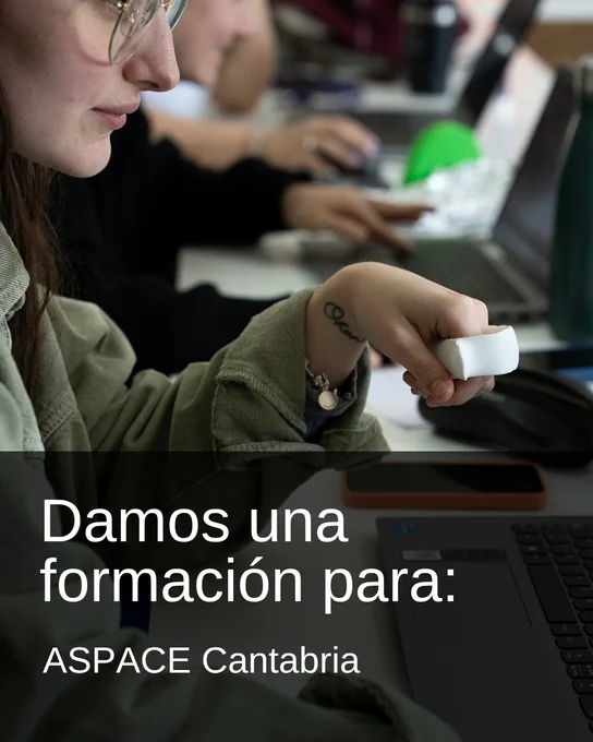 Persona con gafas utilizando un ordenador portátil mientras sostiene una pieza blanca en la mano, en un entorno de formación. Texto sobreimpreso: “Damos una formación para: ASPACE Cantabria”.