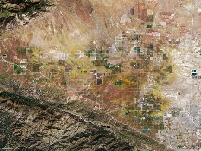 Satellite image of Antelope Valley (on 20 March) featuring a patchwork of agricultural fields and desert terrain, with geometric plots bordered by nearby mountains.