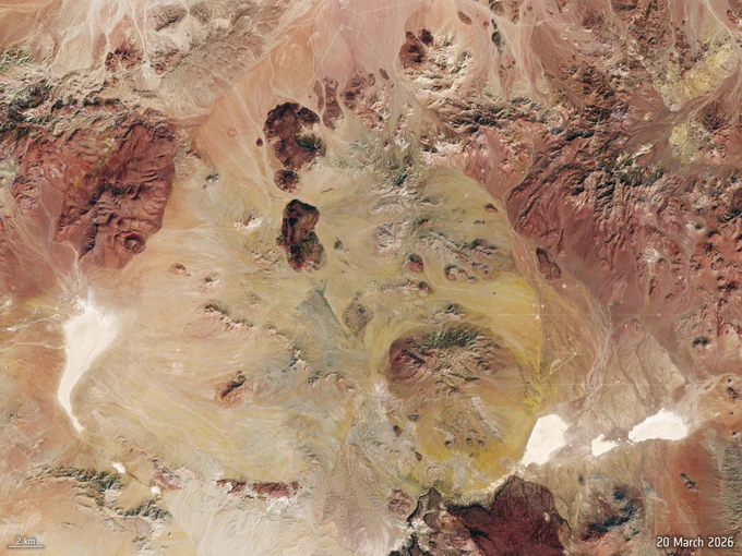 Satellite image of Grass Valley (on 20 March) showing a rugged desert landscape with rocky outcrops and sandy flats in shades of brown, red, and yellow.