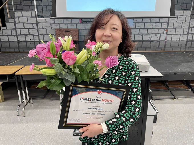 Ms. Jung poses with flowers and certificate