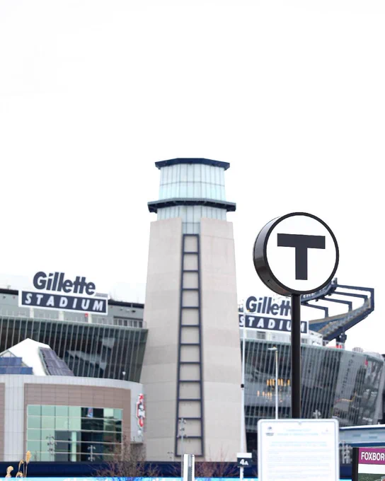 View of Gillette Stadium with a "T" public transit sign.