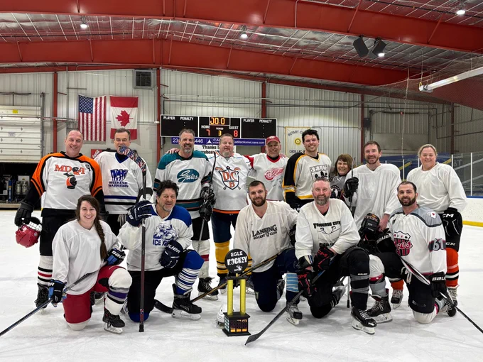 The 13 members of the EGLE hockey team – and one player for
the DNR – pose with the trophy.