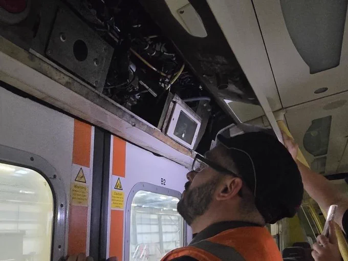 Shaun looks at the exposed circuitry of a 507 door mechanism