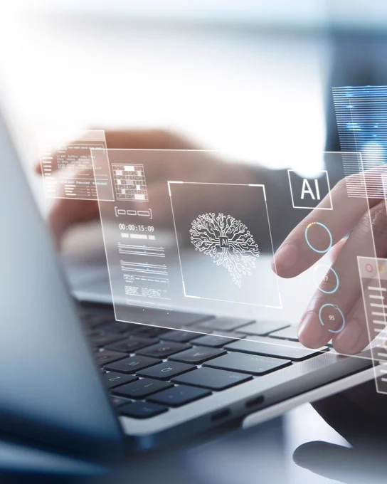 Image of someone typing on a laptop with projected AI pop-up bubbles. 