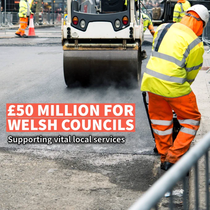 Construction workers in high-visibility gear operating a road roller, with text that reads '£50 million for Welsh Councils, supporting vital local services'.