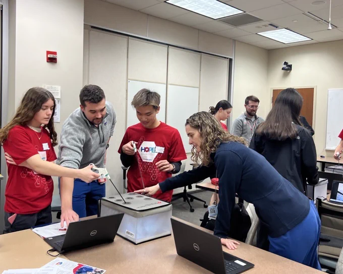 Dr. Elise Lawson and another volunteer teaches laparoscopic skills to students