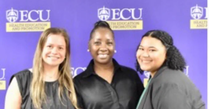 Three individuals smiling in front of a purple ECU Health Education and Promotion backdrop.