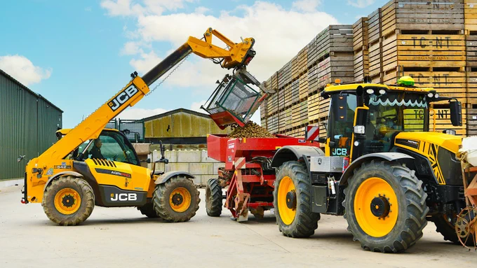 A JCB Loadall and JCB Fastrac working together to load potatoes.