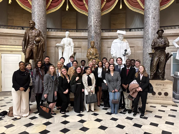 Several students pose with statues in Washington, D.C.