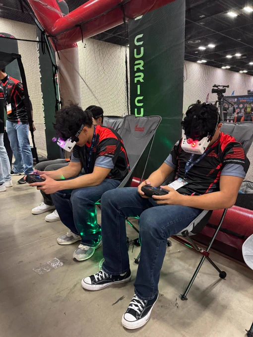 High school students flying racing drones with FPV goggles.