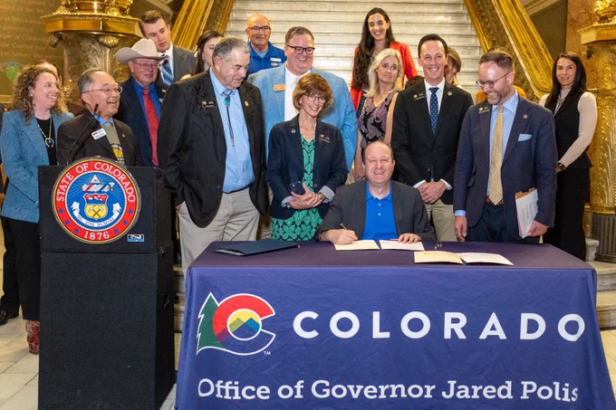Governor Jared Polis signing a proclamation