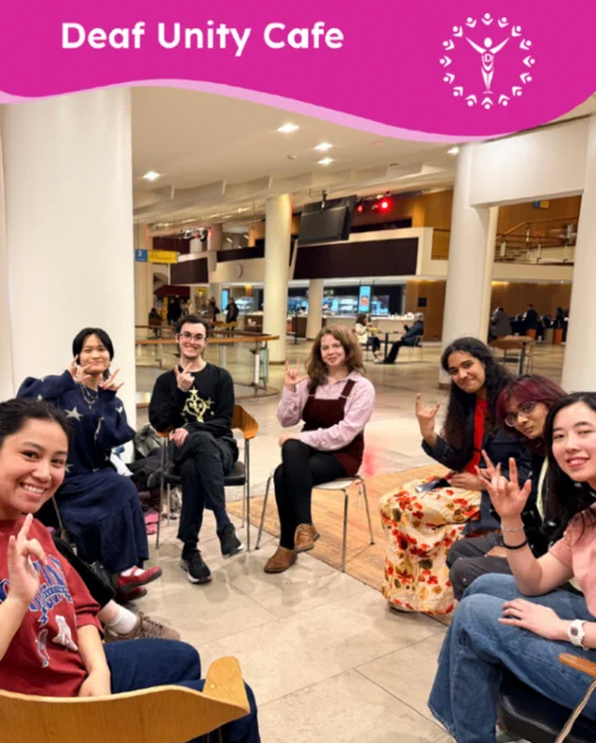 Smiling group seated at Deaf Unity Cafe