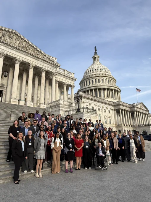 80 students stand in front of the US Capitol