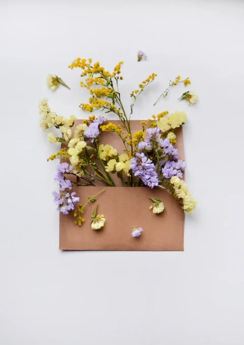 A brown envelope full of yellow and purple flowers.