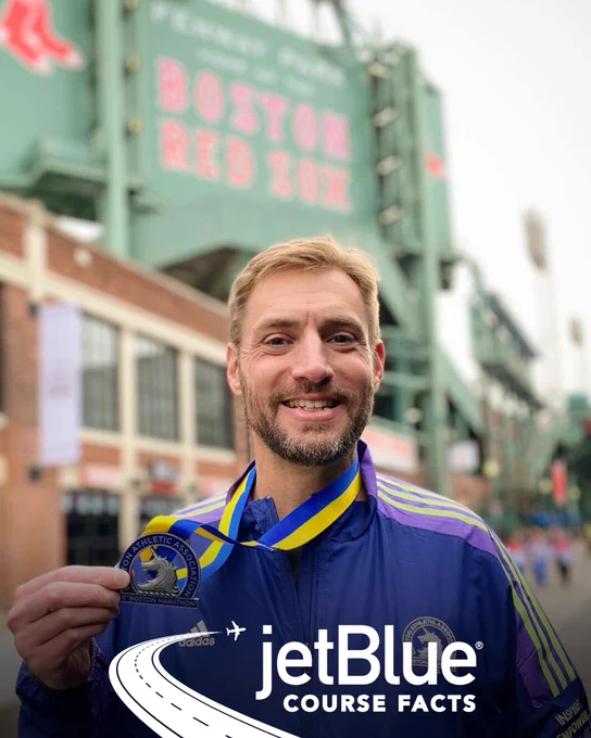 Photo of a Boston Marathon participant showcasing their unicorn medal in front of Fenway Park with the “jetBlue COURSE FACTS” badge overlayed at the bottom center