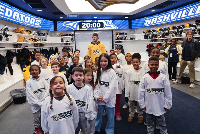 Image of Roman Josi and the CORE program skaters posing for a group photo in the Preds locker room tonight 
