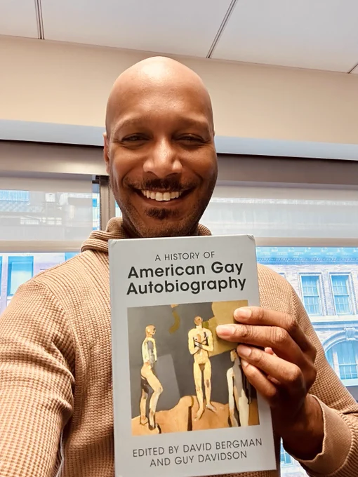 Photo of me holding a copy of A History of American Gay Autobiography and grinning intemperately.