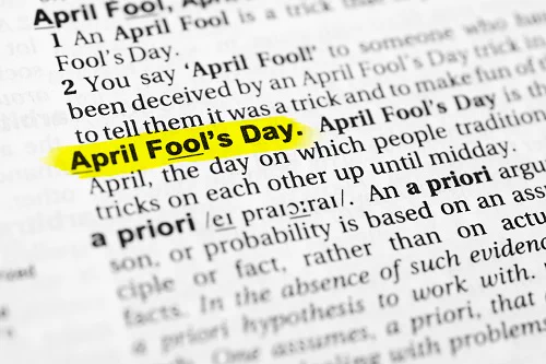 Shutterstock Image, April Fool's Day encyclopedia entry defining the day with entries before and after blurred on the page