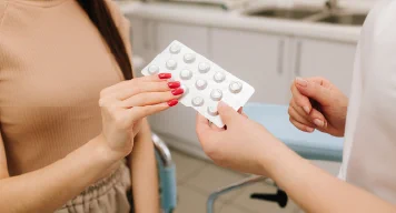 Woman holding pack of birth control pills