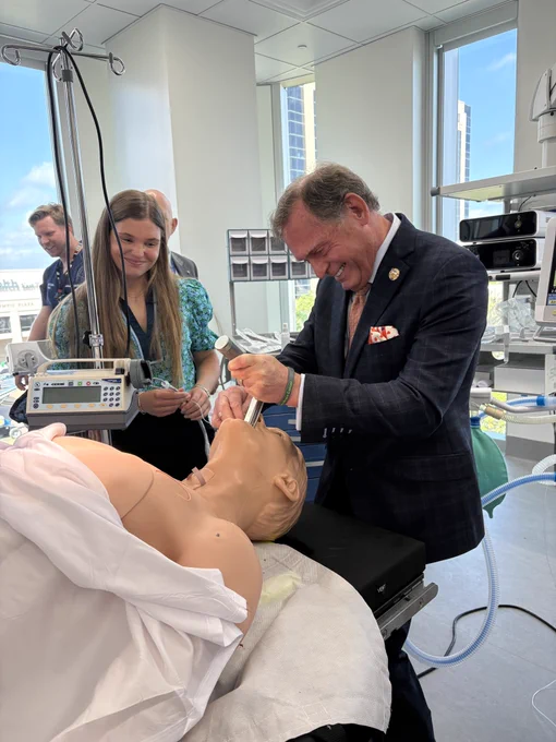 Sam Schott watches Chancellor John Zerwas intubate a manikin in one of the School of Medicine simulation rooms.