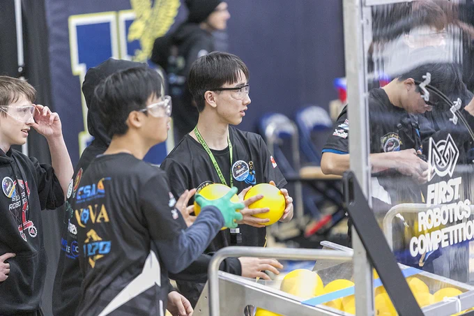 People are wearing safety glasses and are holding yellow balls.
