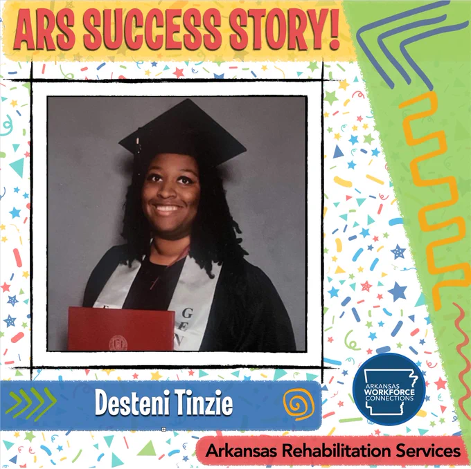 Desteni smiles holding her college diploma and wearing her cap and gown.