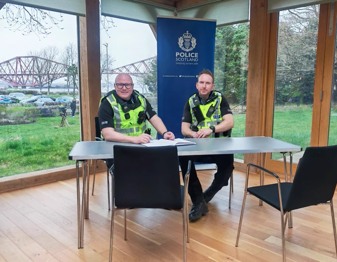 2 police officers sit Infront of a back drop of the Forth Rail Bridge